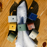 Collection of colourful washable paper napkin rings on a wooden surface
