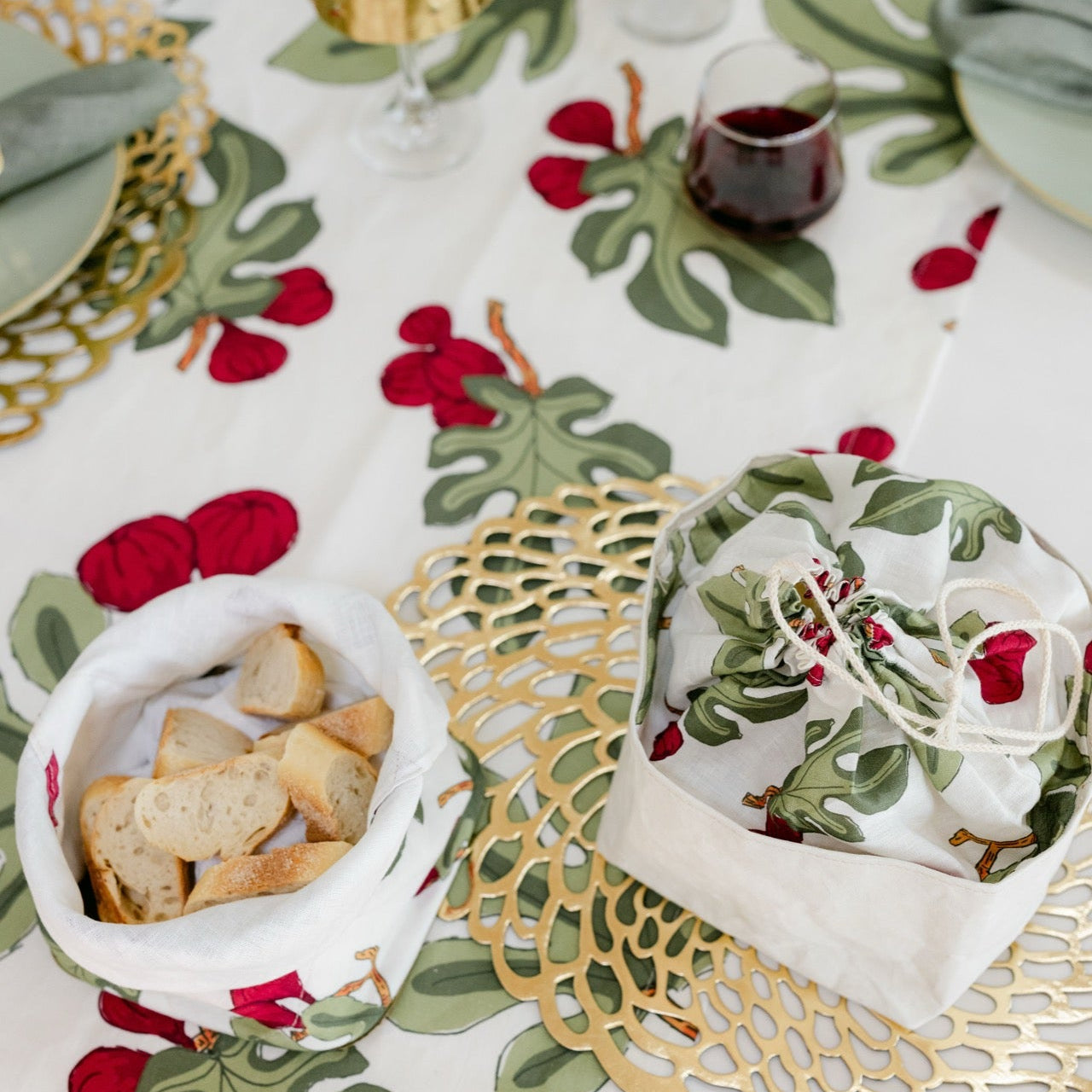 Decorative table setting with a floral tablecloth, gold doilies, and festive bread.