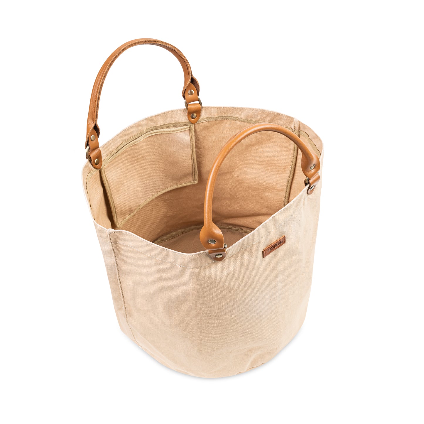 The interior of a round cotton tote bag shows one internal pocket and small leather handles
