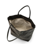 Interior of small black woven handbag showing internal pockets