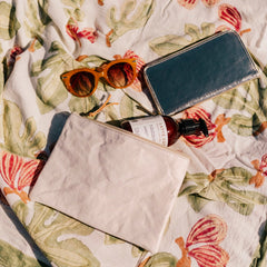 Sunglasses, wallet, and bottle on a floral-patterned fabric