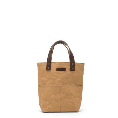 A brown washable paper tote bag with two short dark brown leather handles