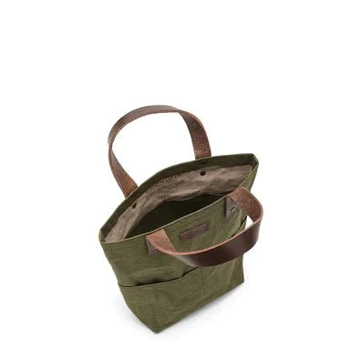 A top down view of a dark green washable paper tote bag showing an internal pocket.