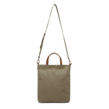 A washable paper tote is shown with a long shoulder strap pointing skywards. It has two top handles and is khaki in colour.