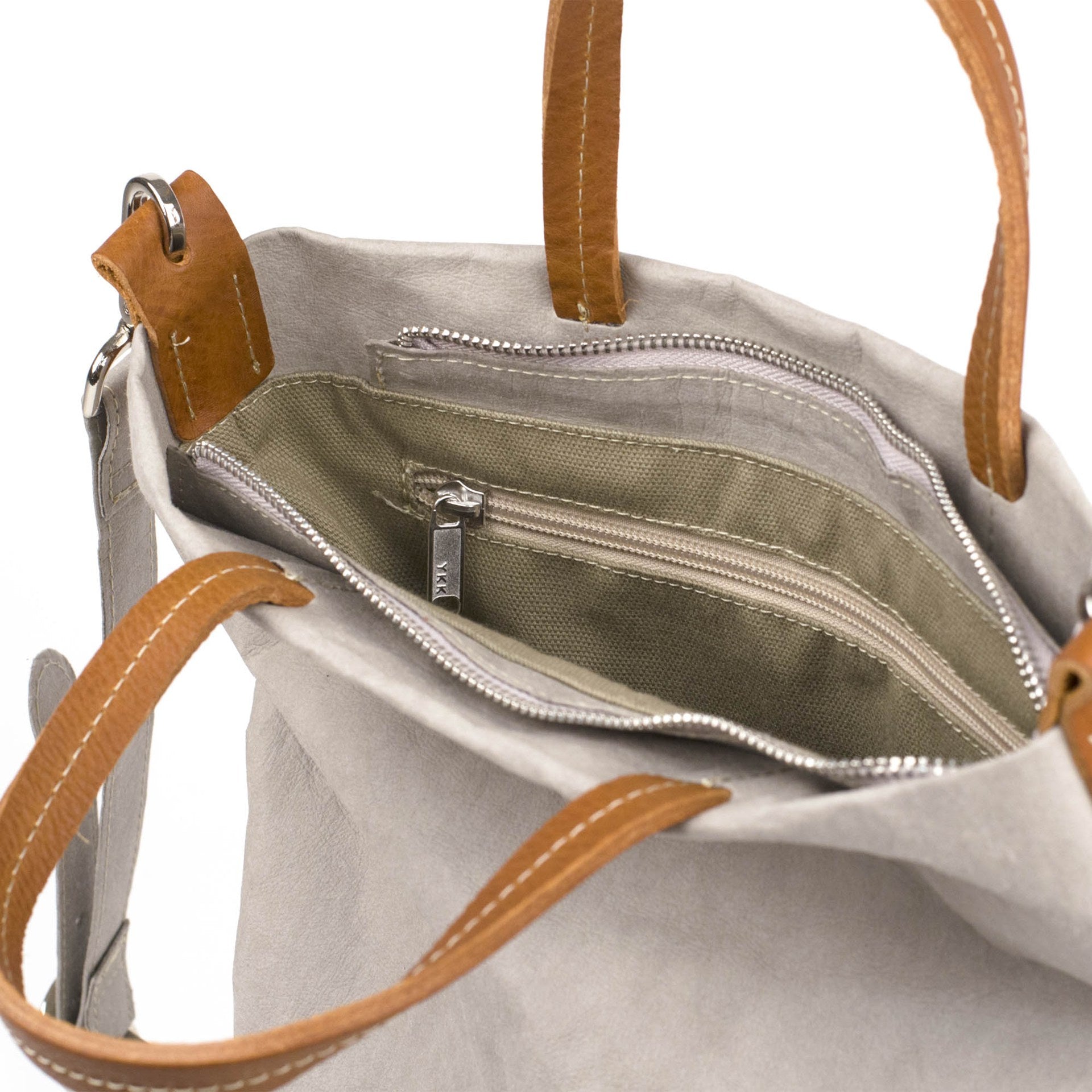 A washable paper tote bag is shown close up and unzipped, revealing an inside zipper pocket. It is beige in colour.