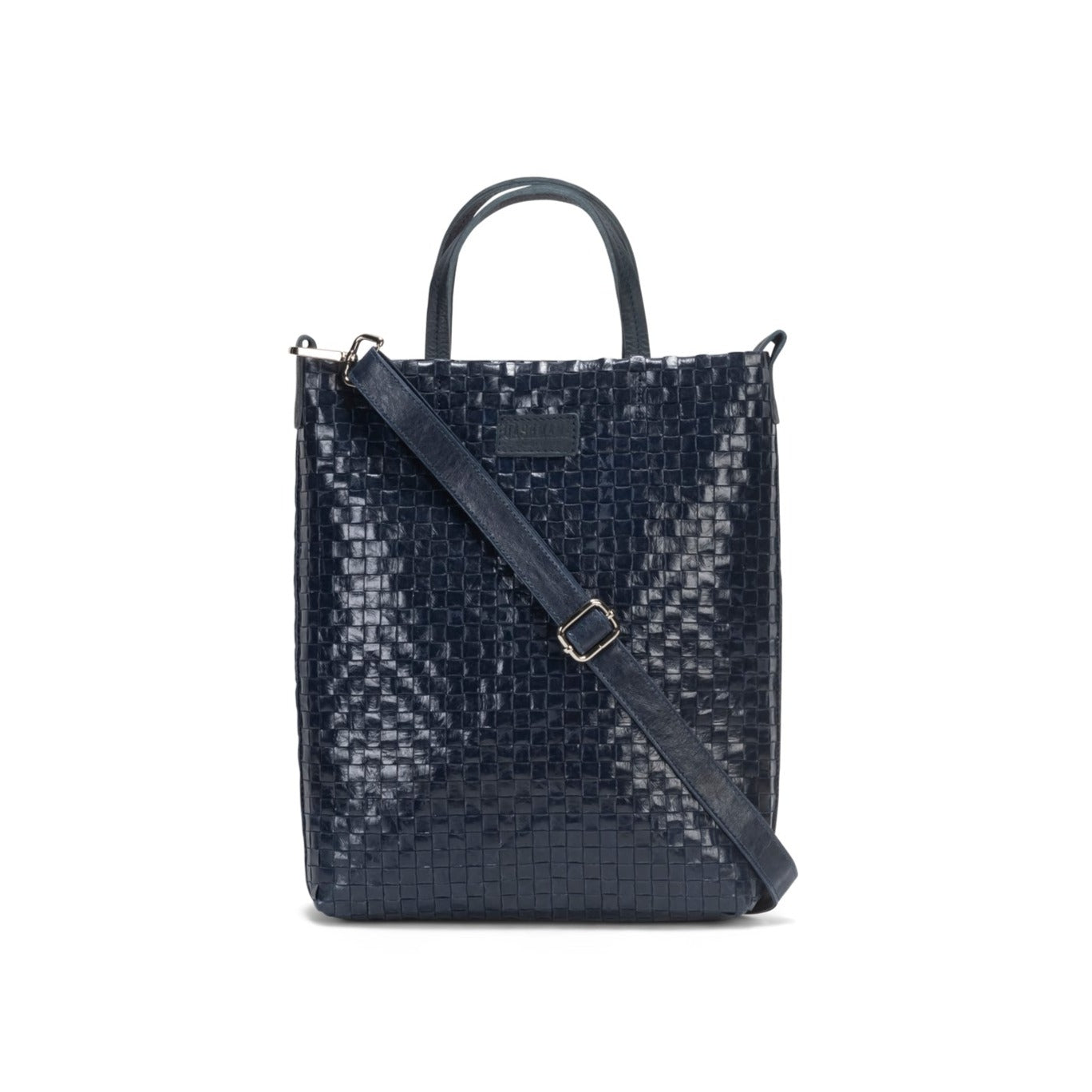 A woven washable paper tote bag is shown from the front angle. It features two top handles and a long adjustable shoulder strap. It is navy in colour.