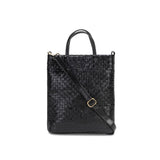 A woven washable paper tote bag is shown from the front angle. It features two top handles and a long adjustable shoulder strap. It is black in colour.