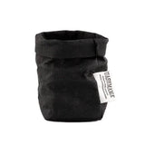 A washable paper bag is shown. The bag is rolled down at the top and features a UASHMAMA logo label on the bottom left corner. The bag pictured is the extra small size in black.