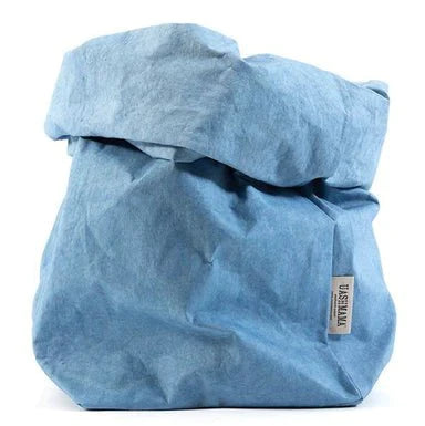 A washable paper bag is shown. The bag is rolled down at the top and features a UASHMAMA logo label on the bottom left corner. The bag pictured is the extra extra large size in light blue.