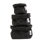 A stack of black washable paper bags go from large, medium and small on the top.