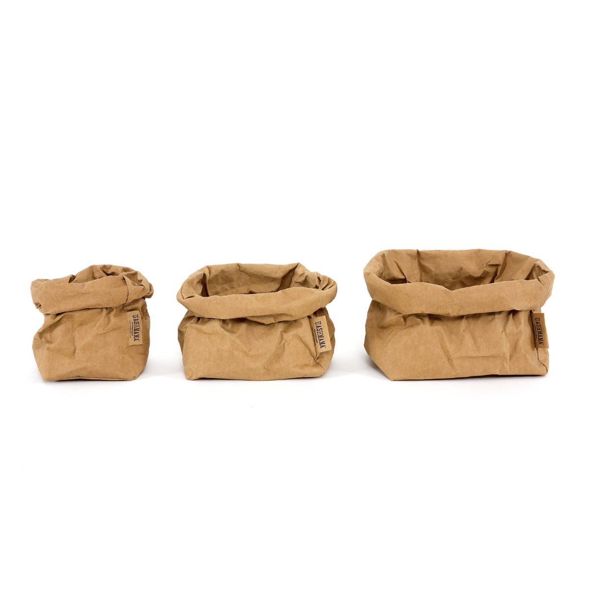 A small, medium and large washable paper bag in a tan colour are lined up from smallest to largest.