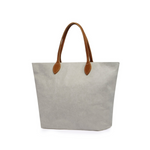 A large washable paper tote is shown. It has two long tan leather handles. The bag shown is pale grey with tan handles.