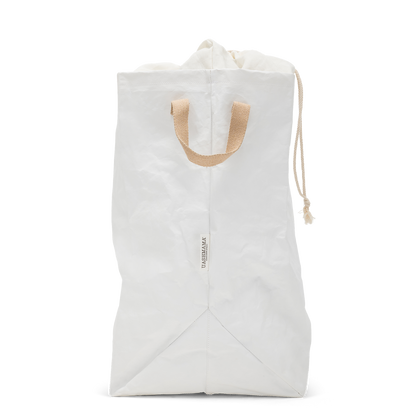 A washable paper laundry bag is shown in white from a side angle. It features two side handles, a popper tab, and an interior drawstring lining.