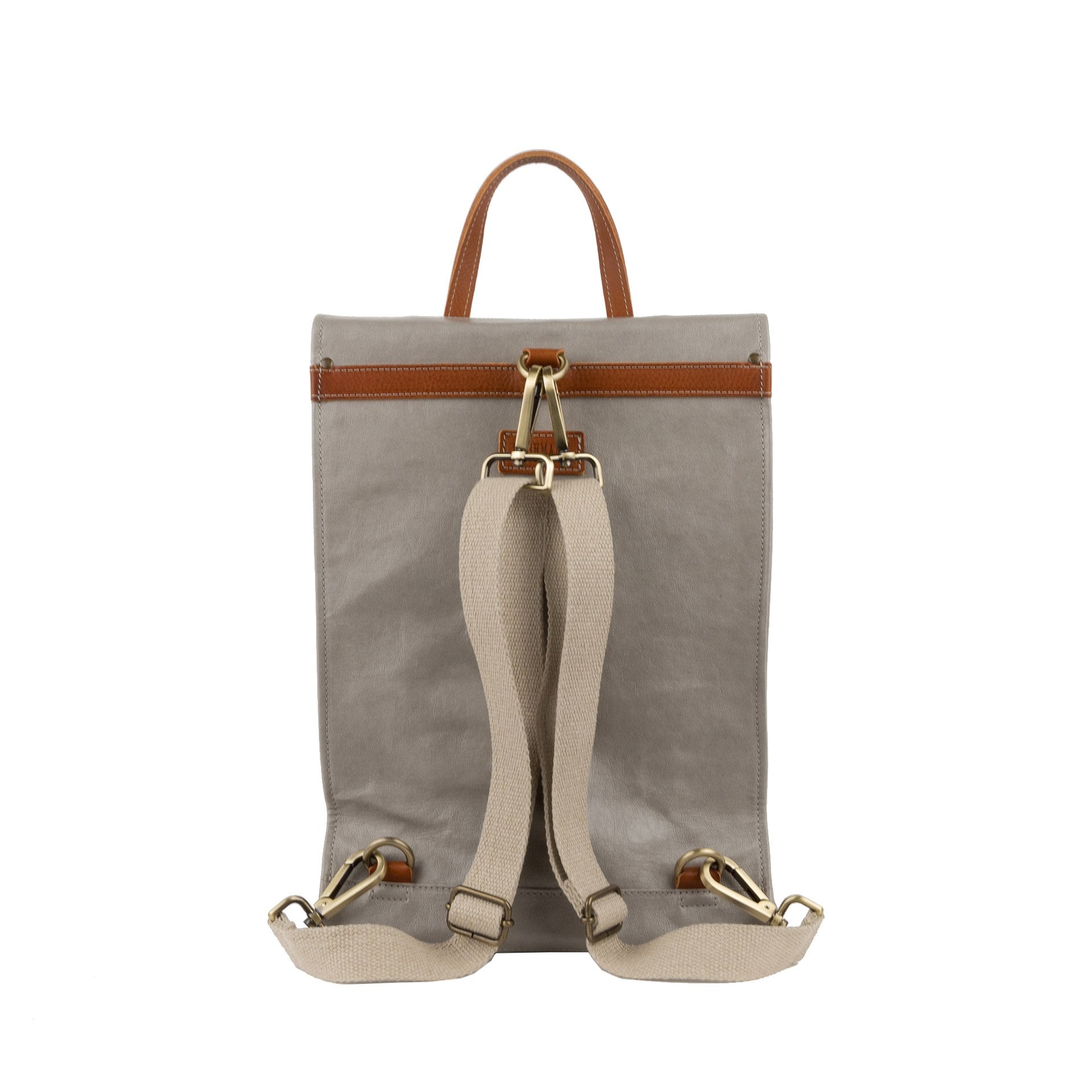 A grey washable paper backpack is shown from the back angle. It features a tan strip across the back, a tan top handle, and cream cotton canvas straps with gold metallic hardware.