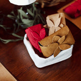 Three washable paper gift cards are shown wrapped in a washable paper tie-handle pouch, inside a white washable paper tray. They are red, beige, and natural tan in colour.