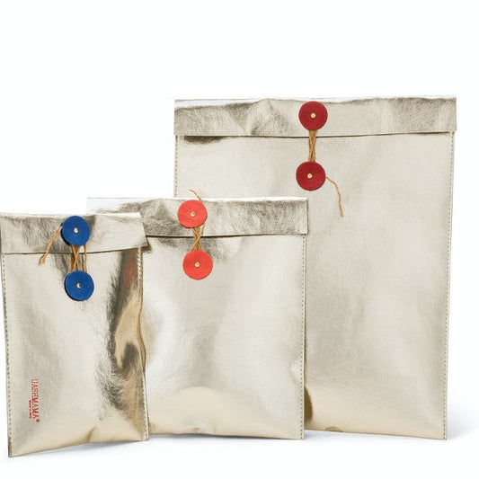 A set of three gold metallic washable paper folio gift pouches are shown in varying sizes. They feature twine closures with round washable paper discs in blue, orange and red respectively.