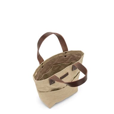 A top down view of the inside of a sand coloured washable paper tote bag. The image shows internal pockets and external pockets and two short brown leather handles.