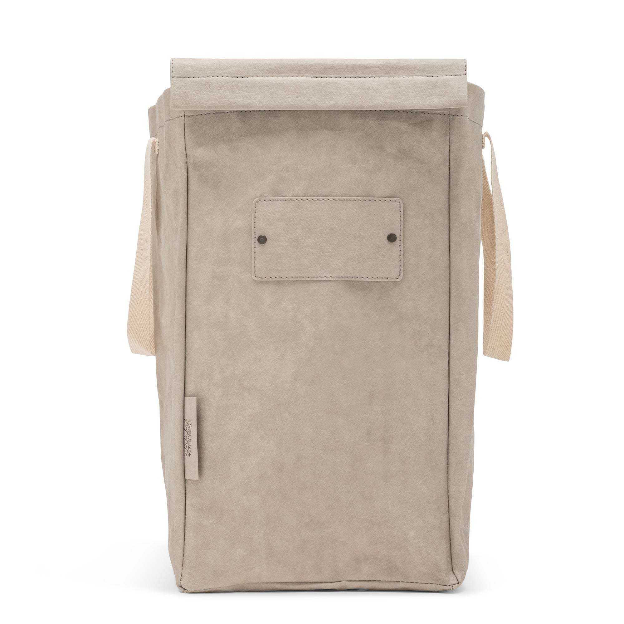 A washable paper recycling bag is shown from the front. The bag has a washable paper  lid which is attached, a washable paper tag attached to the front by two metal studs, and two recycled cotton straps - one on each side. The bag has a UASHMAMA label on the front left side. The bag shown is pale grey.