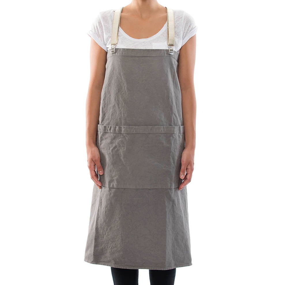 A person is shown standing wearing a dark grey cotton apron which is fastened over their shoulders with washable paper braces.