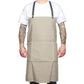 A man is shown standing wearing a beige cotton apron with washable paper straps.