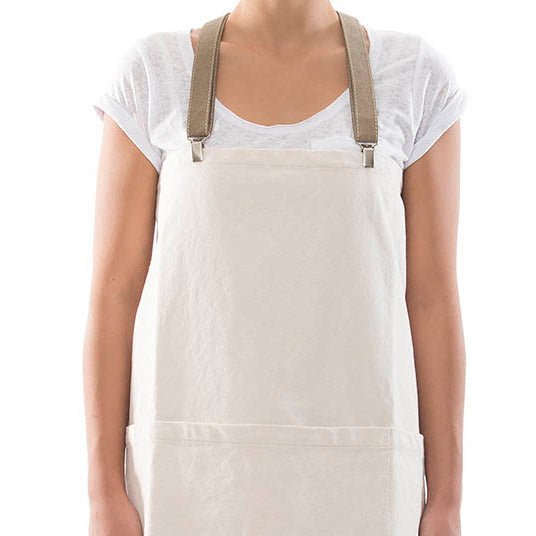 A man is shown standing wearing a white cotton apron with washable paper straps.