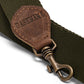 A olive strap is shown with washable paper details and a metallic retractable clip.