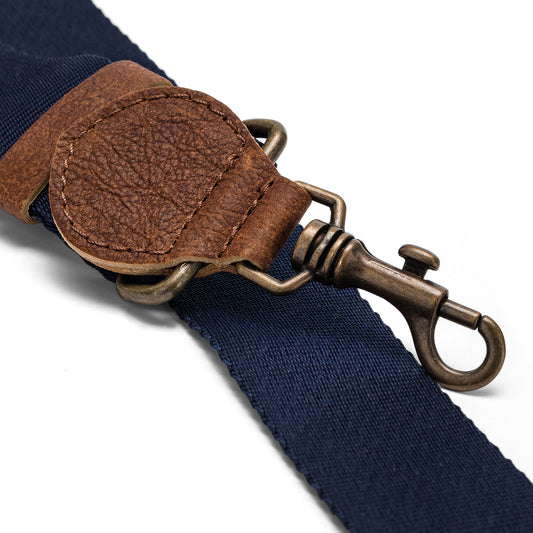 A navy strap is shown with washable paper details and a metallic retractable clip.