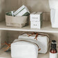 The image shows two shelves. On the top shelf is a washable paper tray in grey containing two boxes of soap. On the bottom shelf are two washable paper toiletry bags in white.
