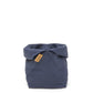 A navy linen bread bag is shown with the top rolled down, open. A brown logo UASHMAMA tag features on the front side.