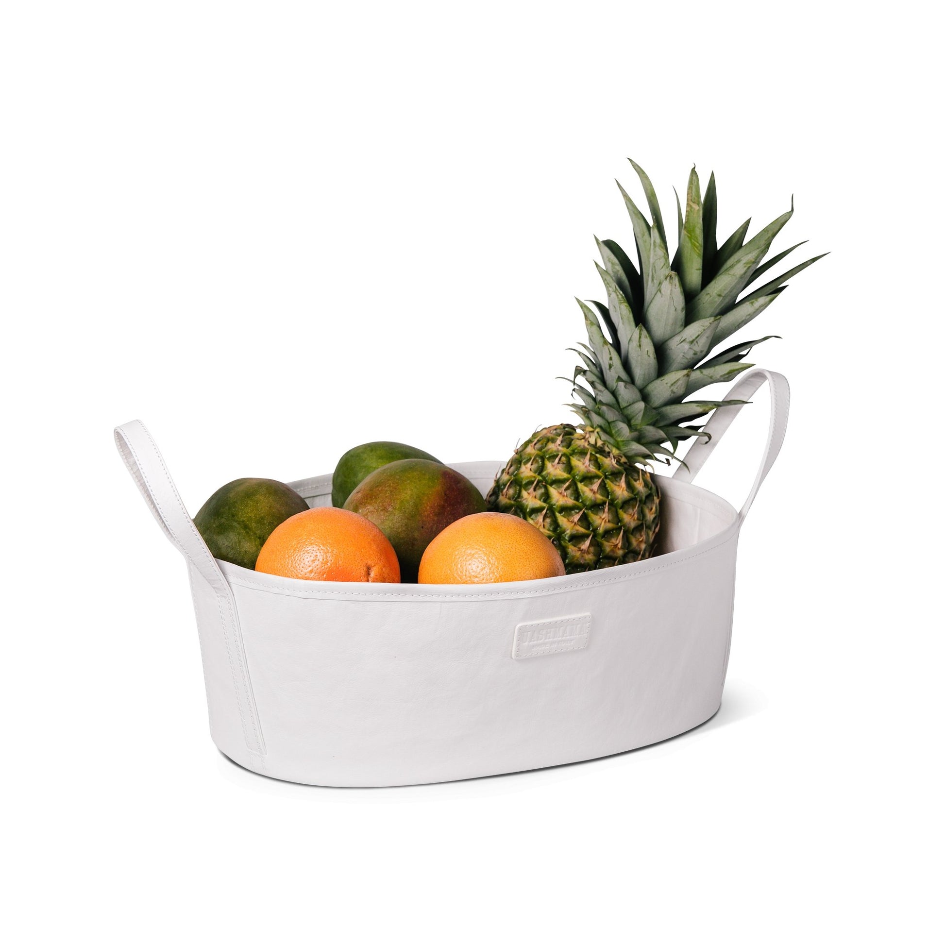 A rounded white oblong storage box made from washable paper is shown holding mangos, oranges and a pineapple.
