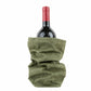 A bottle of red wine is shown inside a green washable paper wine holder.