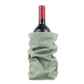 A bottle of red wine is shown inside a pale green washable paper wine holder.