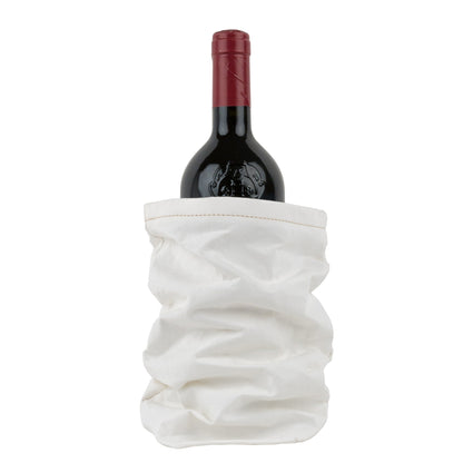 A bottle of red wine is shown inside a white washable paper wine holder.