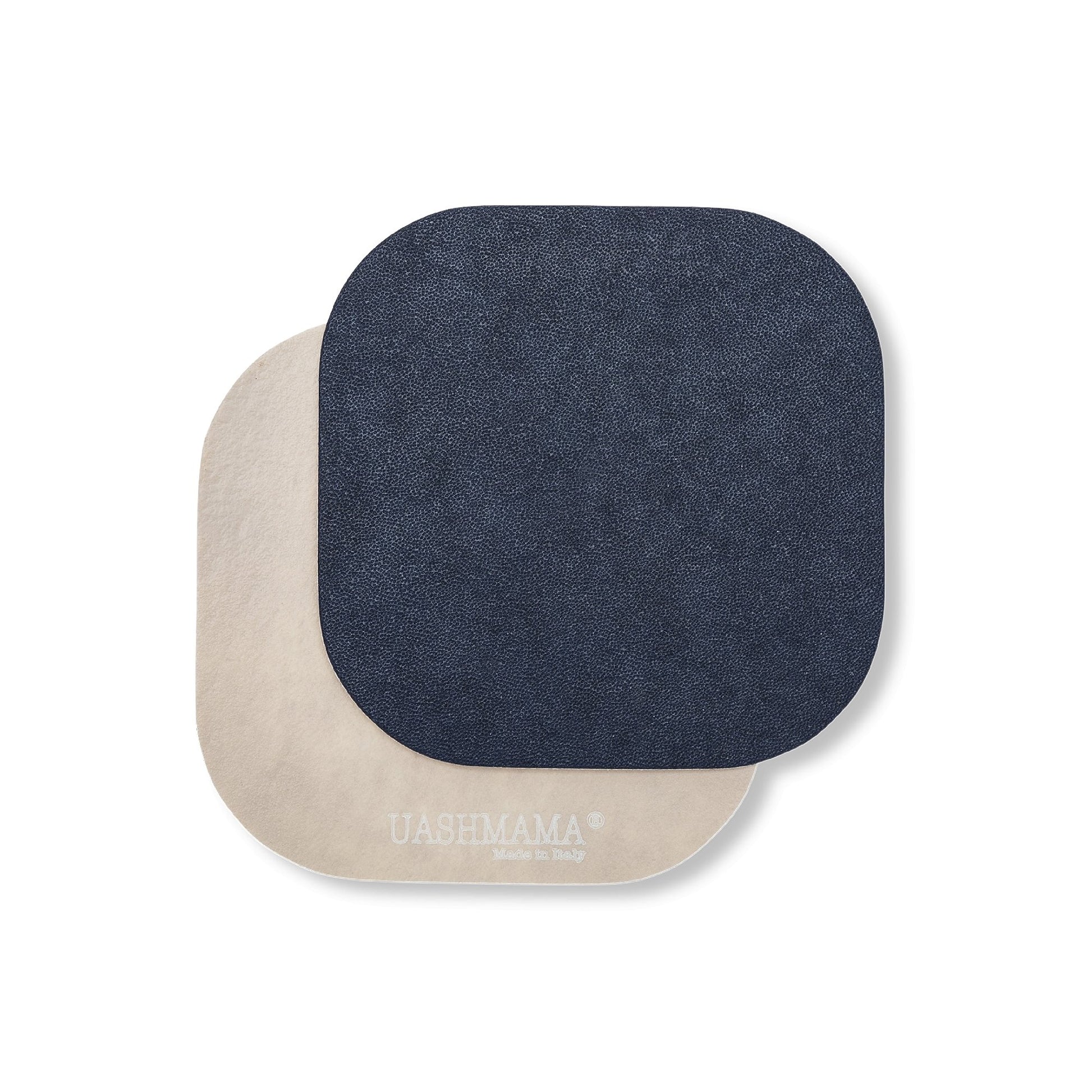 Two rounded edge square washable paper coasters lie one atop the other. The one in the foreground is navy and the one at rear is beige.