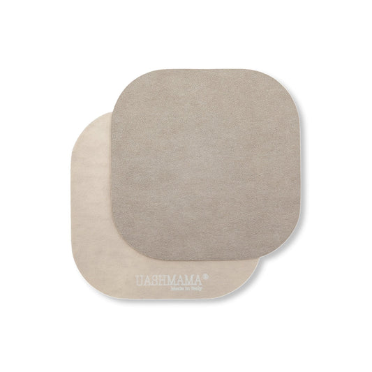 Two rounded edge square washable paper coasters lie one atop the other. The one in the foreground is grey and the one at rear is beige.