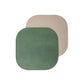 Two rounded edge square washable paper coasters lie one atop the other. The one in the foreground is green and the one at rear is beige.