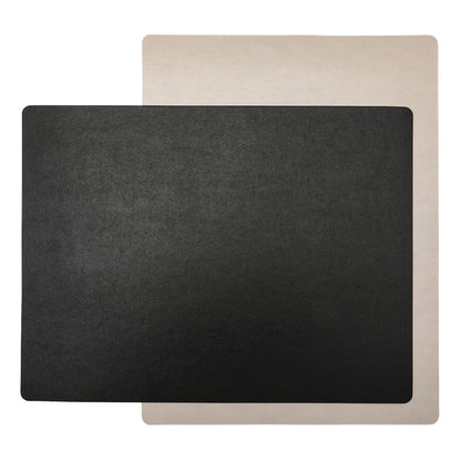Two rectangular washable paper placemats are stacked one on top of the other, at contrasting angles. The one in the foreground is black and the one at rear is beige.