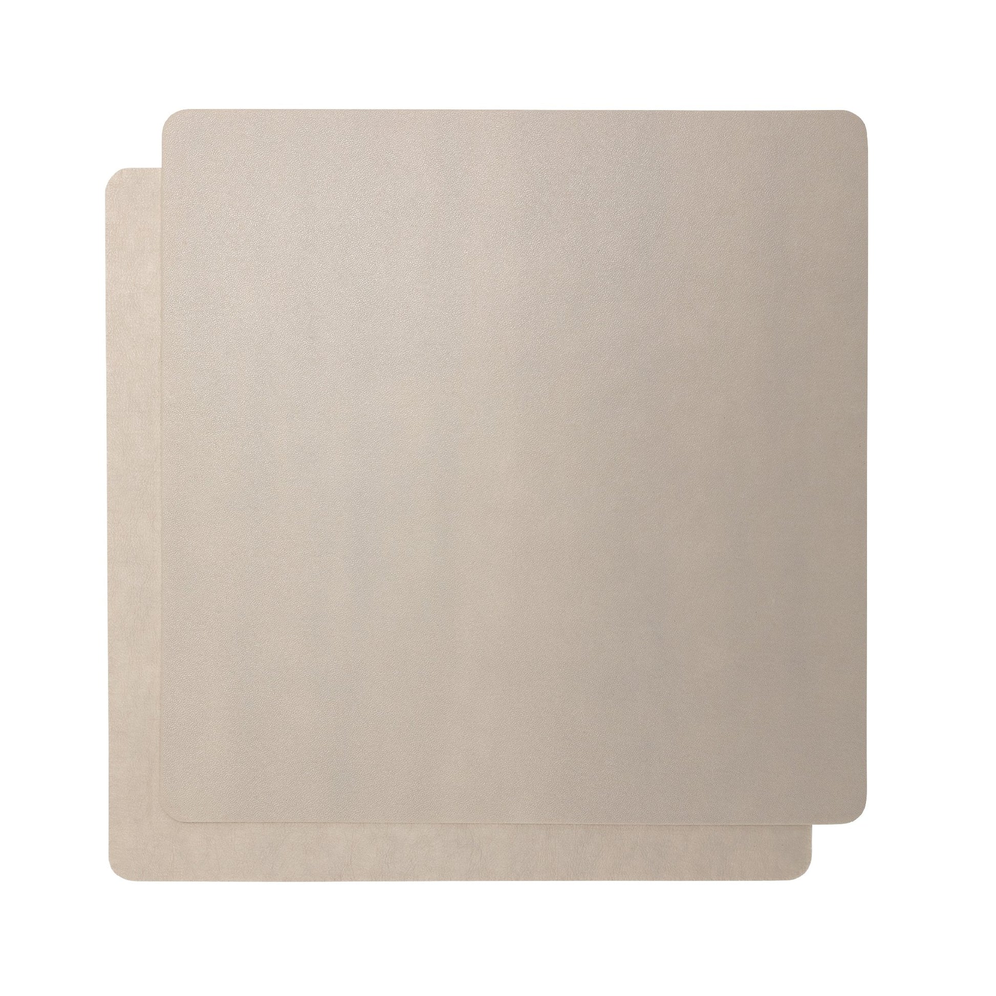 Two beige square washable paper placemats are shown one on top of the other. 