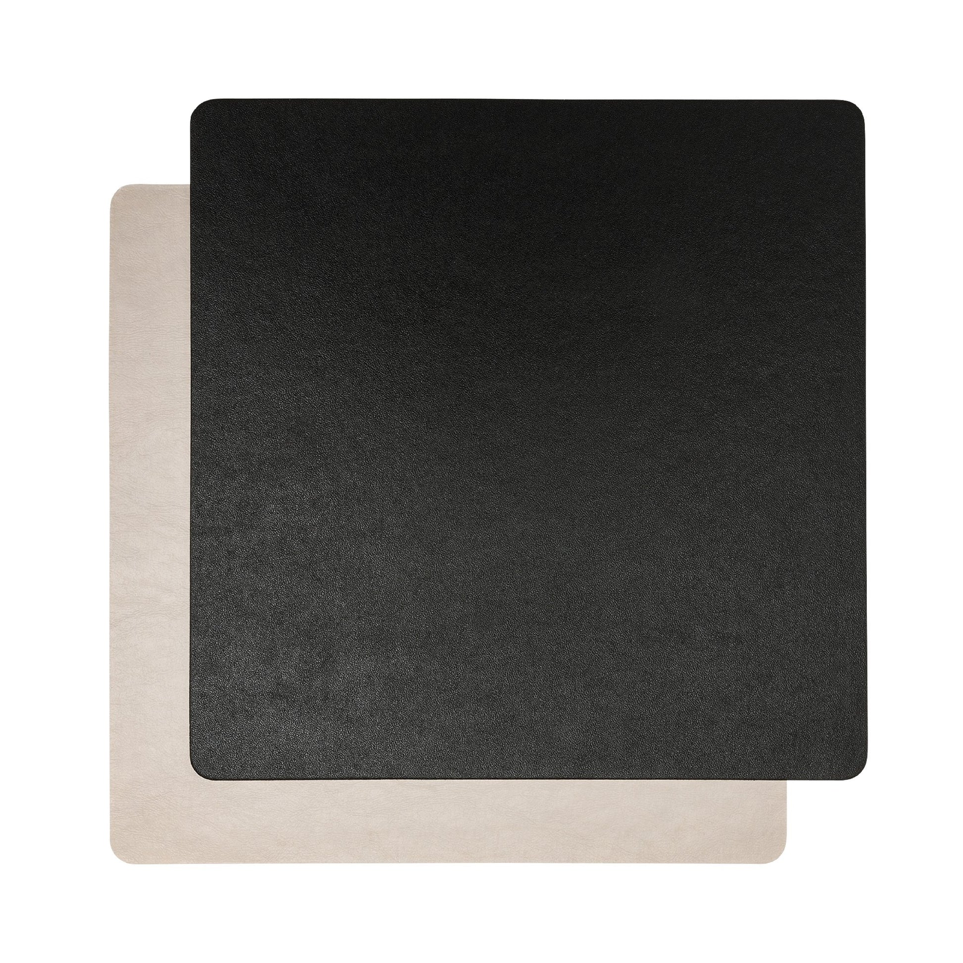 Two square washable paper placemats are shown one on top of the other. The one in the foreground is black and the one at the rear is beige.