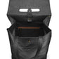 A black washable paper backpack with a top handle is shown open, from a top-down angle. It features an interior zip closure and a metal and paper tab closure.
