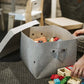 A woman is shown sorting legos into a washable paper box in grey, the lid sits at back.