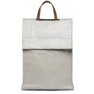 A tall rectangular square-edged washable paper backpack with a front flap and a brown handle is shown in a pale grey colour. 