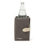 A dark grey washable paper cooler is shown with a washable paper side tab with silver stud. It contains a glass water bottle.