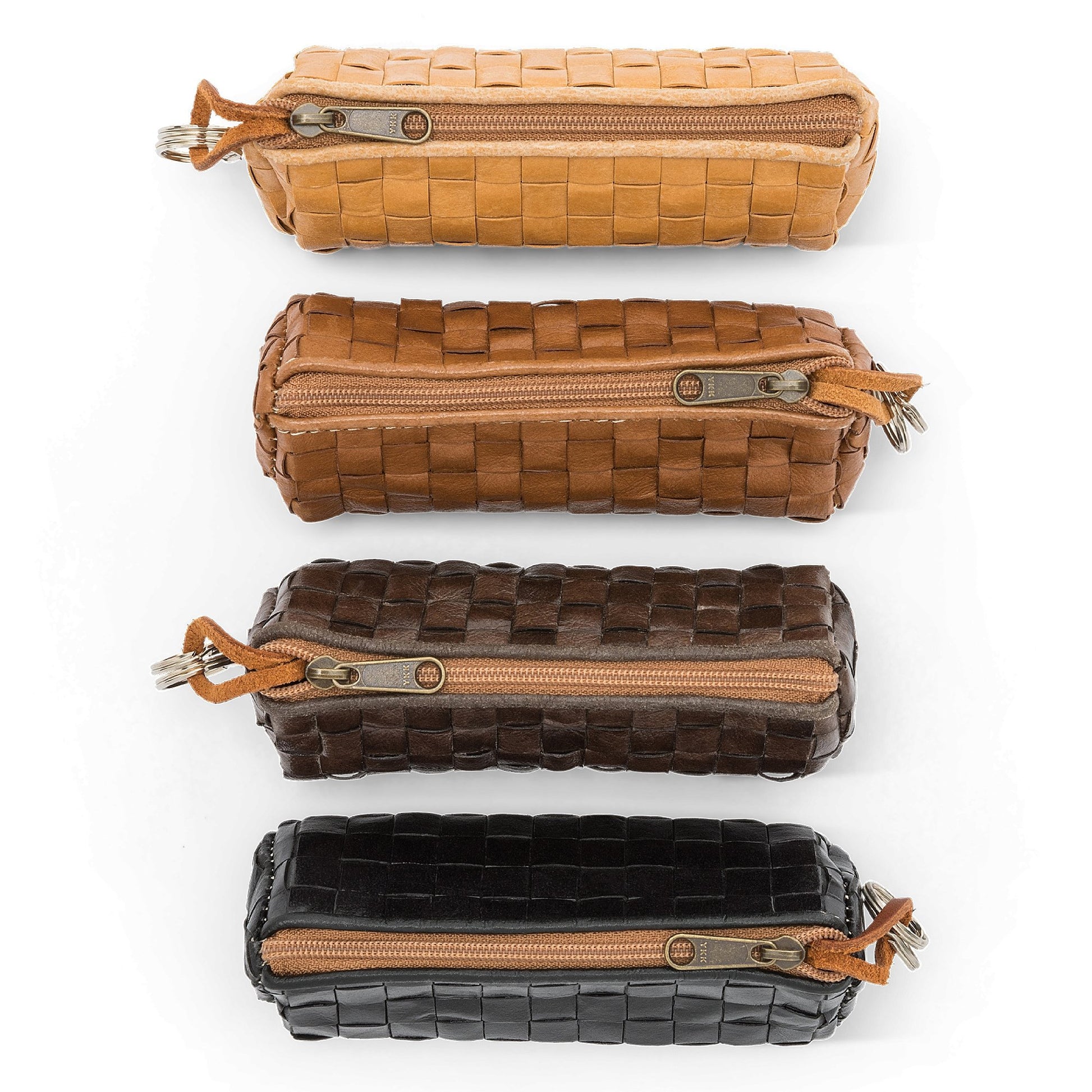 Four woven washable paper key holders are shown from a top angle. From top they are tan, brown, chocolate brown and black, all with brown zips.