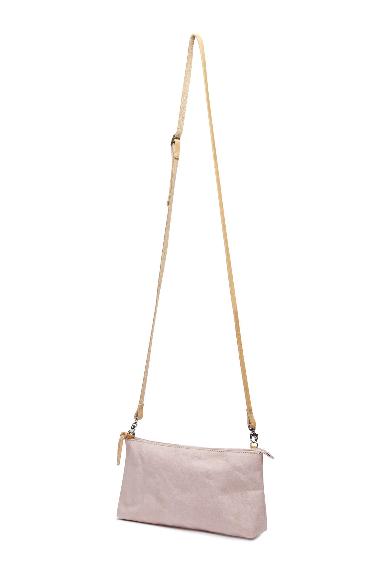 A pale pink washable paper small zip top handbag is shown with a long tan washable paper strap.