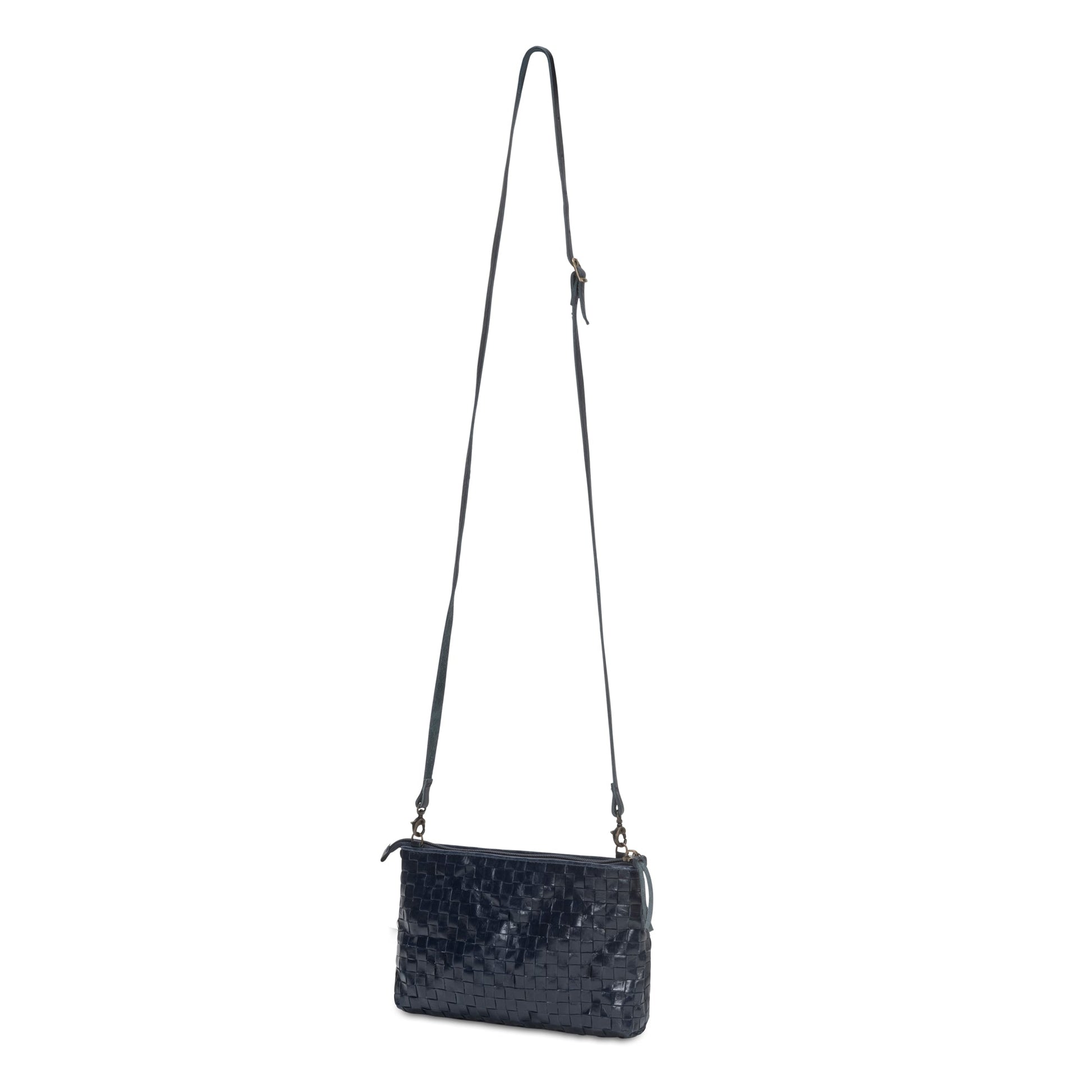 A black shiny woven washable paper small zip top handbag is shown with a long washable paper strap.