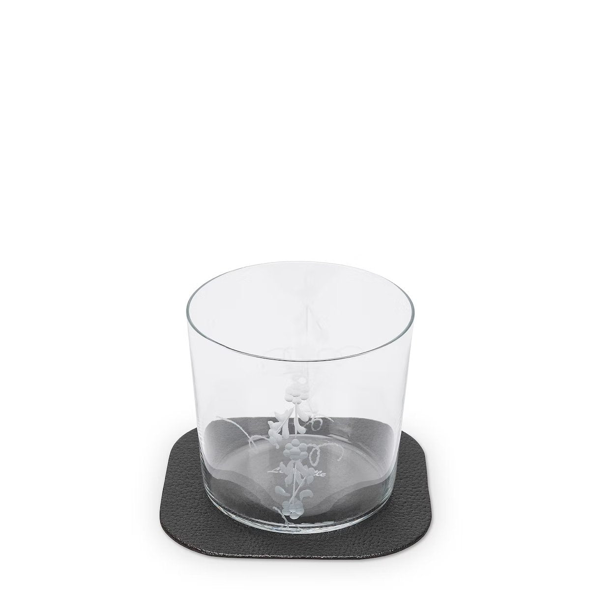 A textured washable paper coaster is shown in black under a water glass.