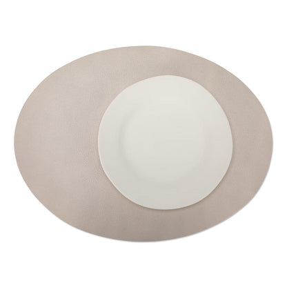 A large oval textured washable paper placemat in beige is shown under a white plate.