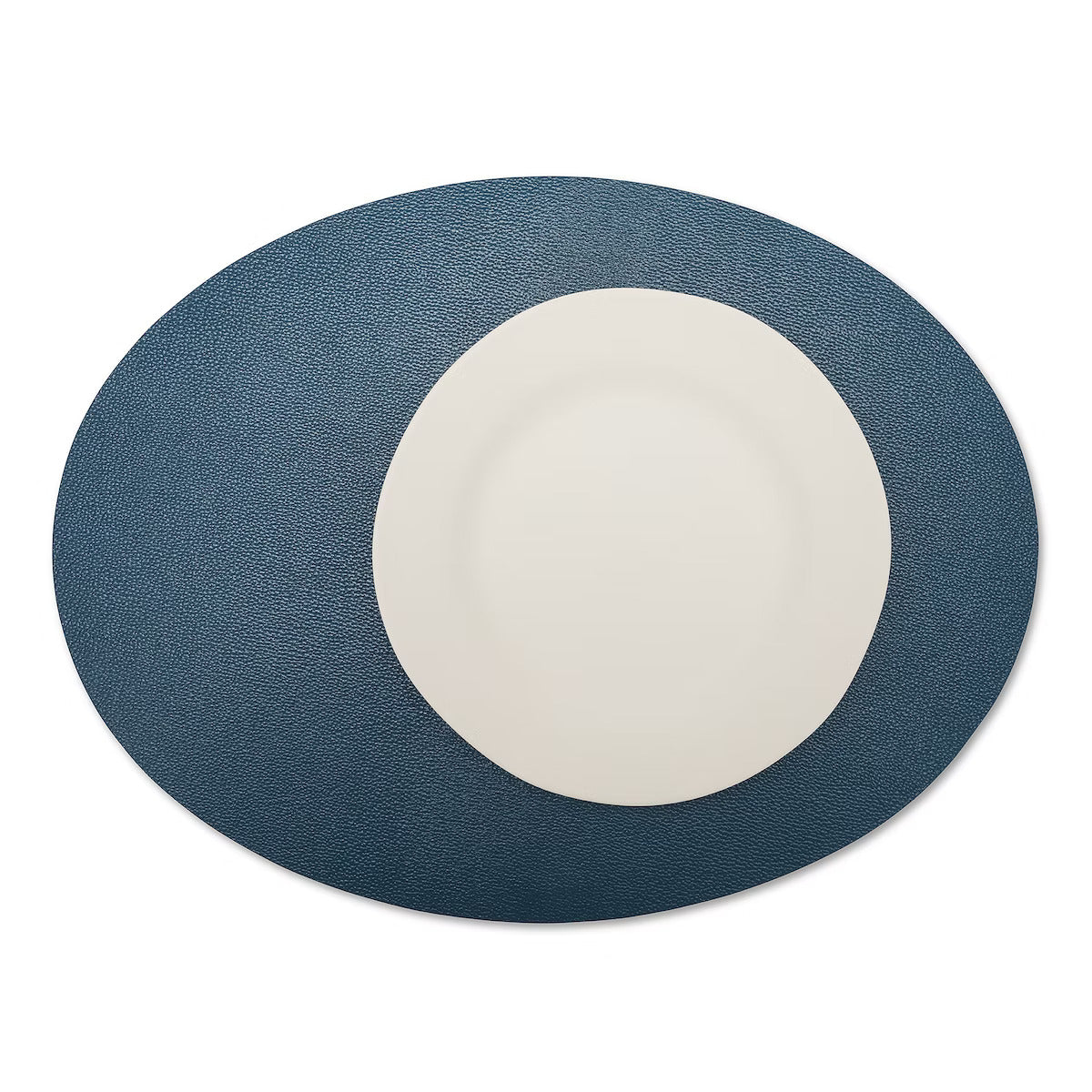 A large oval textured washable paper placemat in navy is shown under a white plate.
