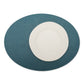 A large oval textured washable paper placemat in teal is shown under a white plate.